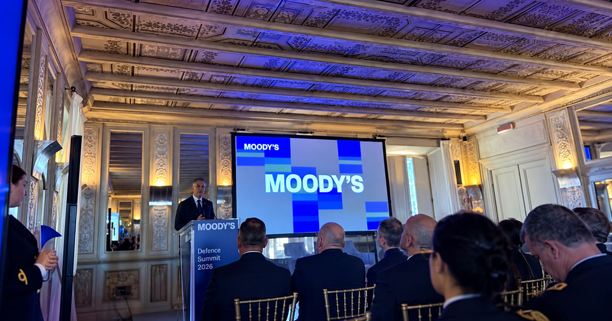 Elaborazione editoriale del Moody’s Defence Summit 2026: schermo e leggio della conferenza
